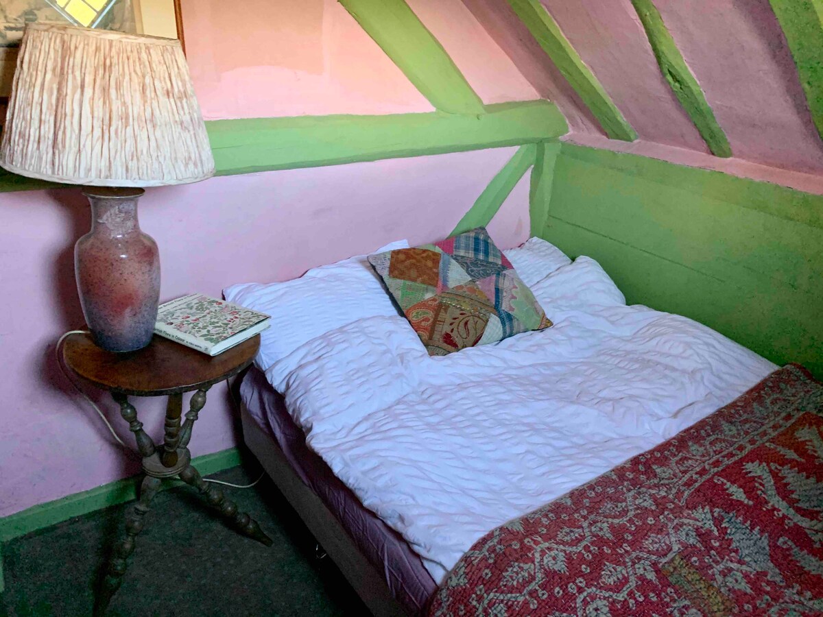 ห้องนอนสีชมพูเล็กๆพร้อมเตียงคู่ขนาดเล็ก 