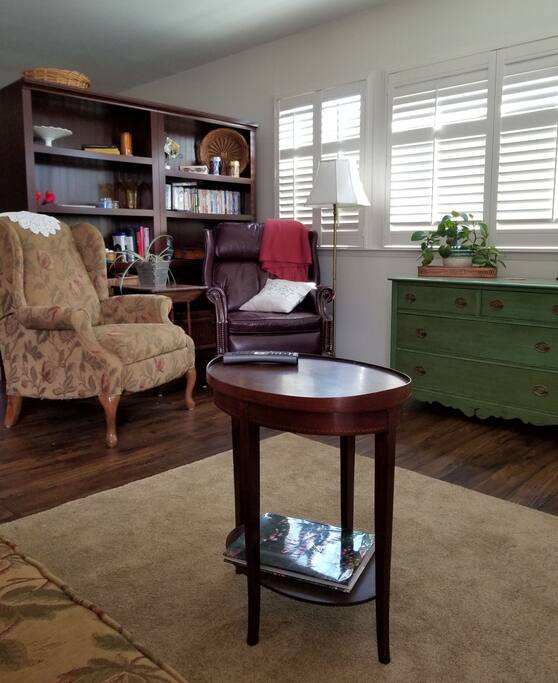 Living area with two recliners, love seat, TV, desk area and bistro table.