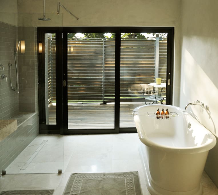 Large marble bathroom with freestanding tub and walk-in shower that open to your private deck.