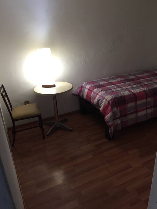 How the room looks from the door. There's a night stand and the bed.