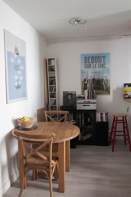 Pièce principale avec une table, deux chaises et quatre tabourets.