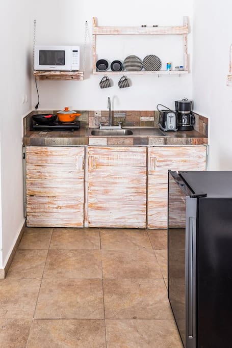 Kitchenette with microwave, mini fridge, electric stovetop, coffer maker and toaster