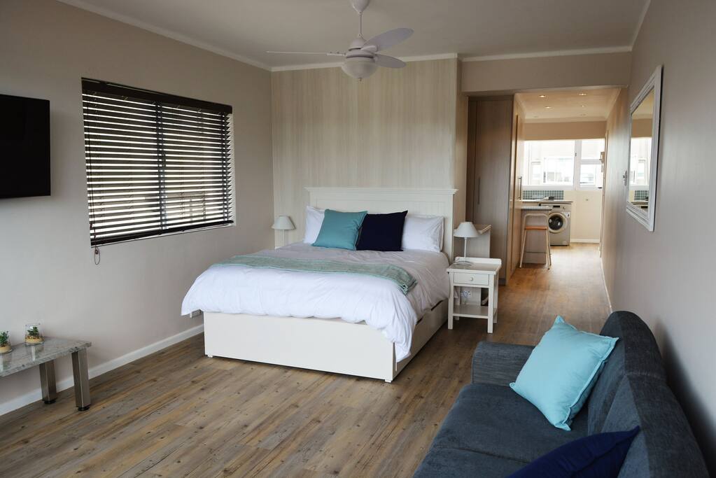 Spacious studio apartment with walk through cupboards behind the bed