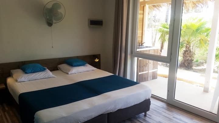 Lichte kamer met comfortabel bed en alle benodigde faciliteiten, eigen veranda met uitzicht op de tropische tuin