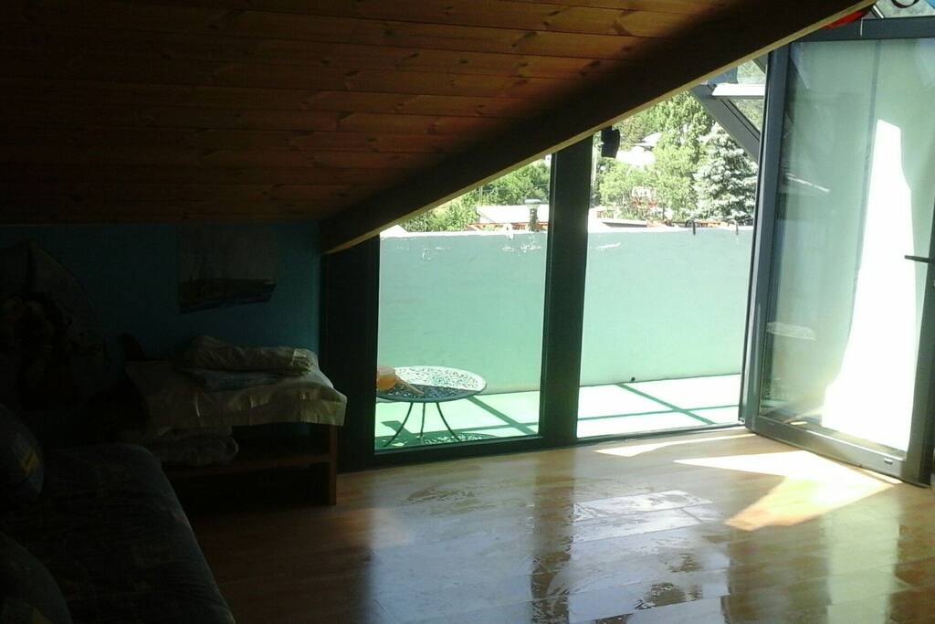 Salon de 20 m2 avec canapé lit et balcon vue sur montagne à 180°