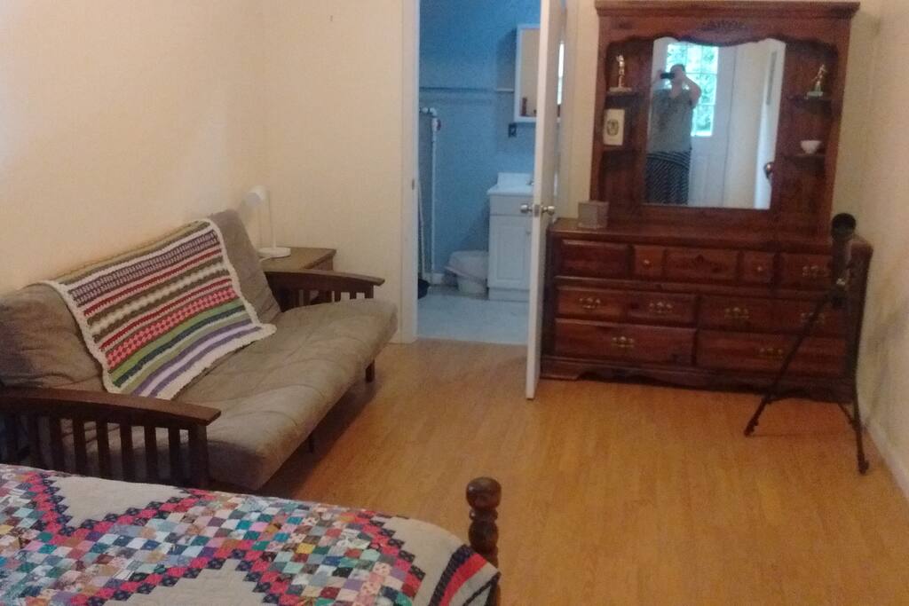 Open living area with futon and dresser.