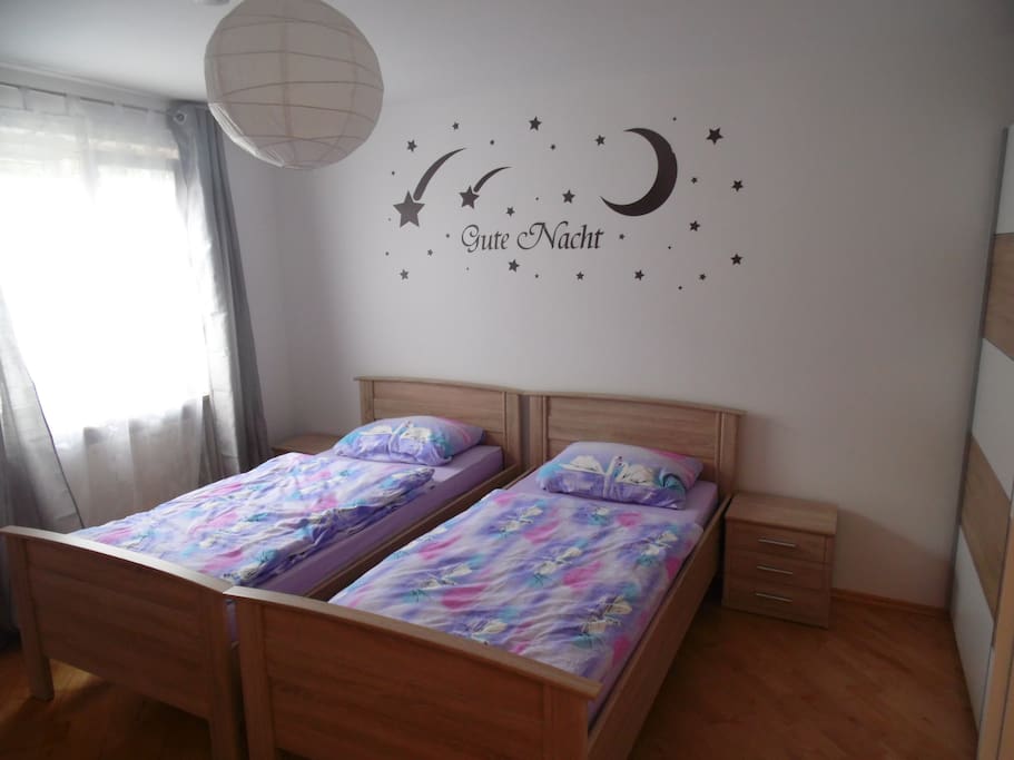 Schlafzimmer mit 2 Betten und Fenster zum Garten
