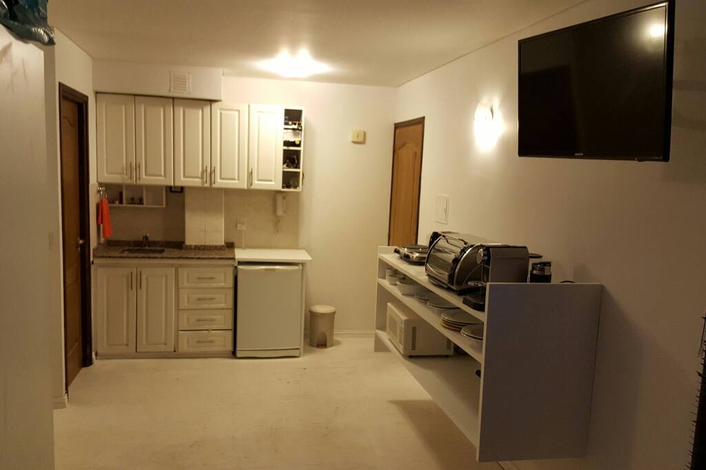 Cocina full electric con TV que se puede ver desde el comedor y desde la cama