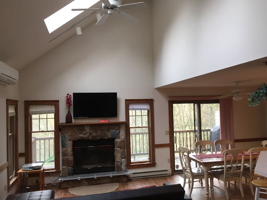 Living room with cathedral ceiling, fireplace, fan and split AC