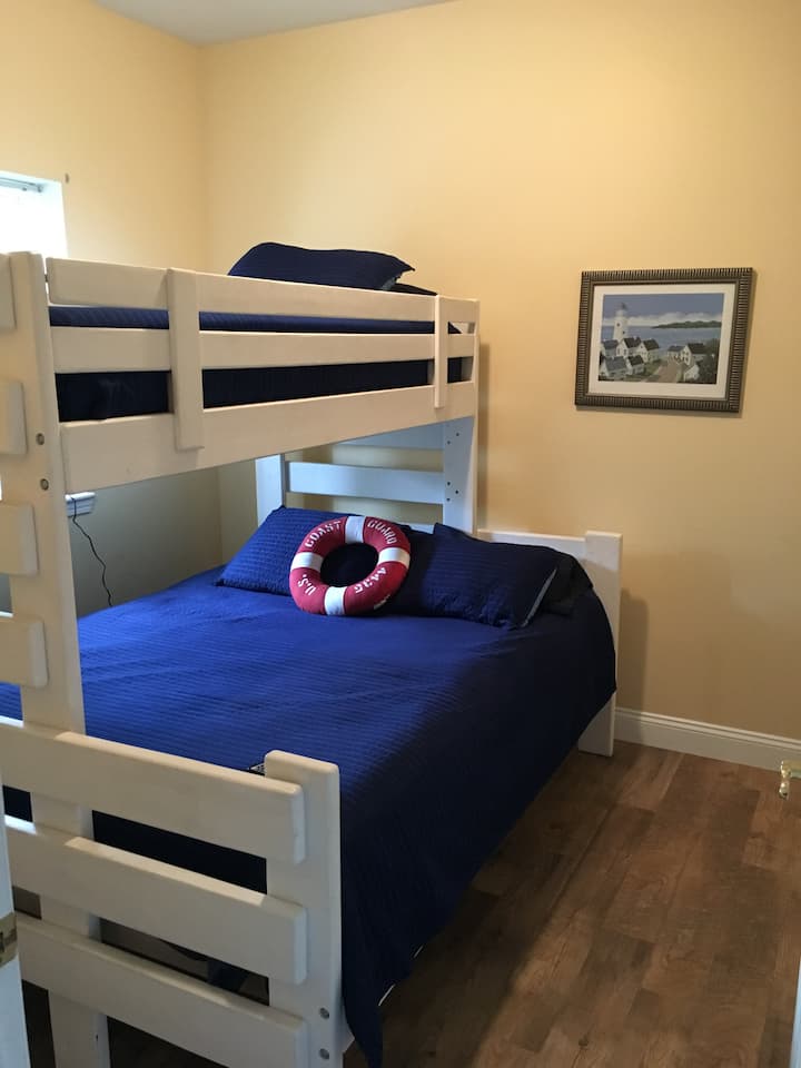 一楼卧室，双人床上有一张超长的双层床 