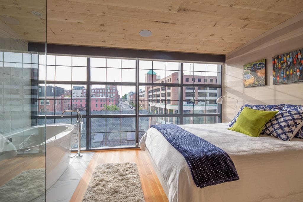 Master bedroom soaking tub and walk-in shower with floor-to-ceiling windows and roller blinds for privacy. Queen bed.