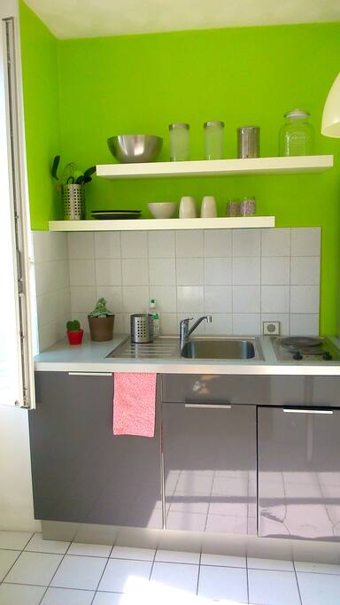 Petite cuisine avec grand frigo, plaques, cafetière, bouilloire, micro-onde, grille-pain.