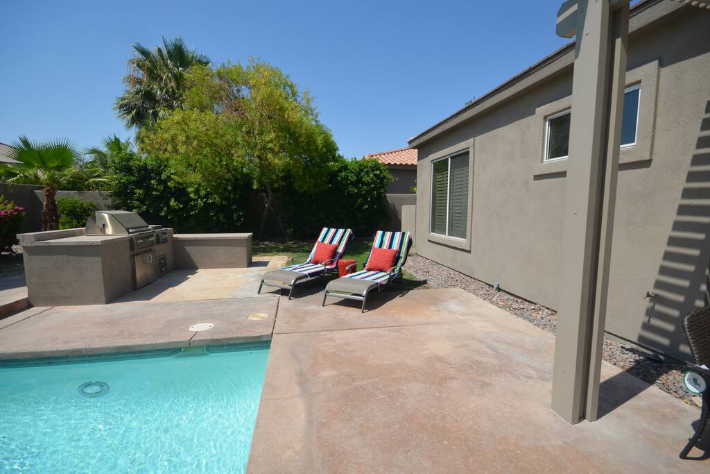 Lounging poolside next outdoor bbq cooking area