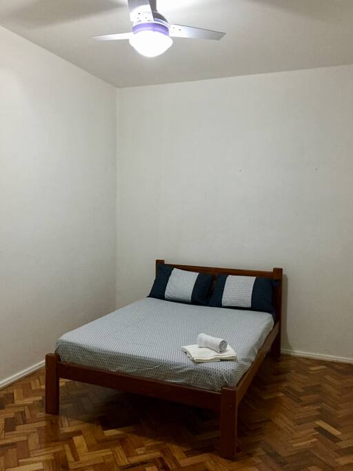Quarto de casal com ar-condicionado e ventilador de teto.