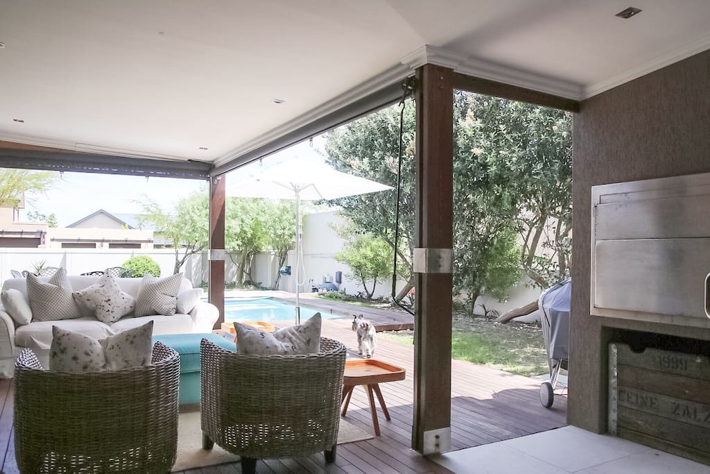 Covered patio with lounge furniture, roller blinds for wind/rain