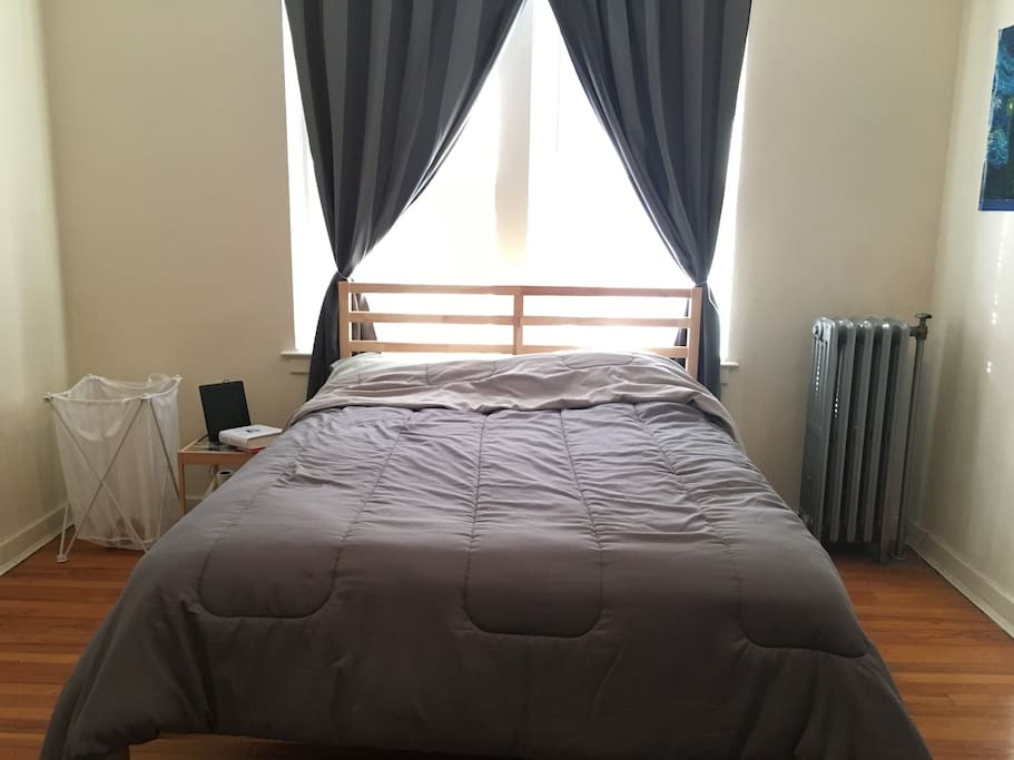 Spacious bedroom with full size bed, large closet, and workspace.