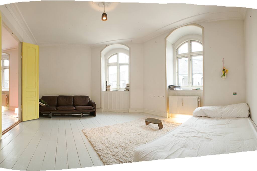 Livingroom with a bed and a sofa (the windows are facing the court yard)