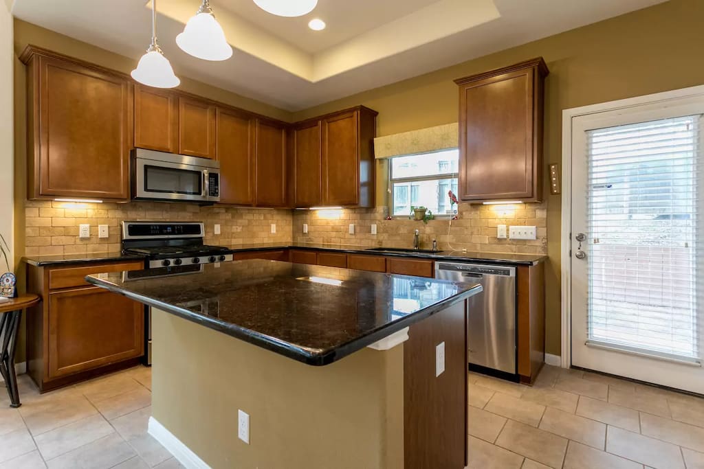 Marble countertops and cabinets full of everything you would need for cooking and baking.
