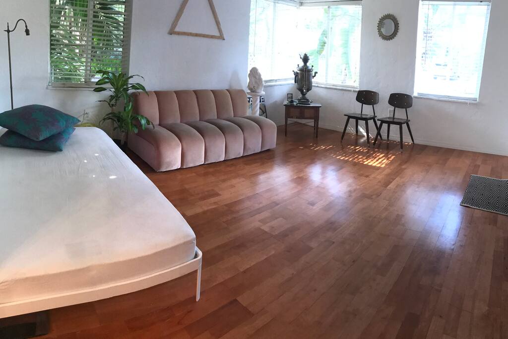 Sunny living room. Original hardwood floors and vintage details. Twin sized daybed.