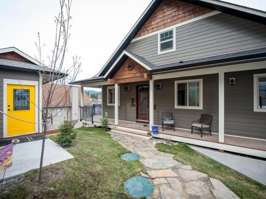 Home entrance with wrap around deck and rock walkway.