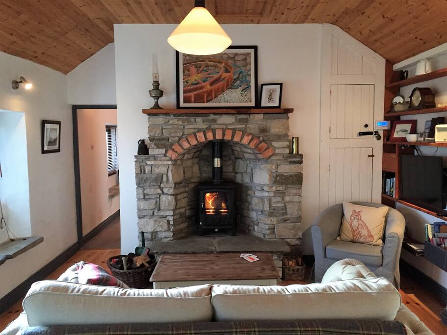Living Room, including solid fuel stove in a newly refinished fireplace, satellite television, and Bluetooth-enabled radio.