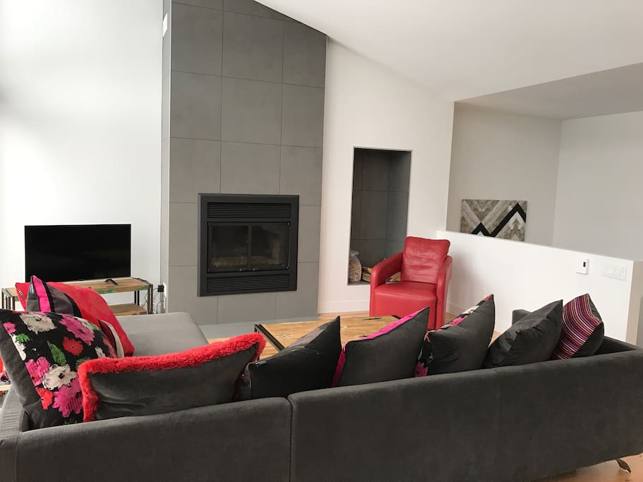 Salon avec foyer au bois et niche pour les bûches