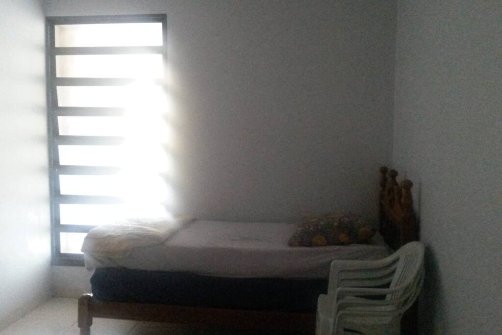 Quarto com cama de solteiro.