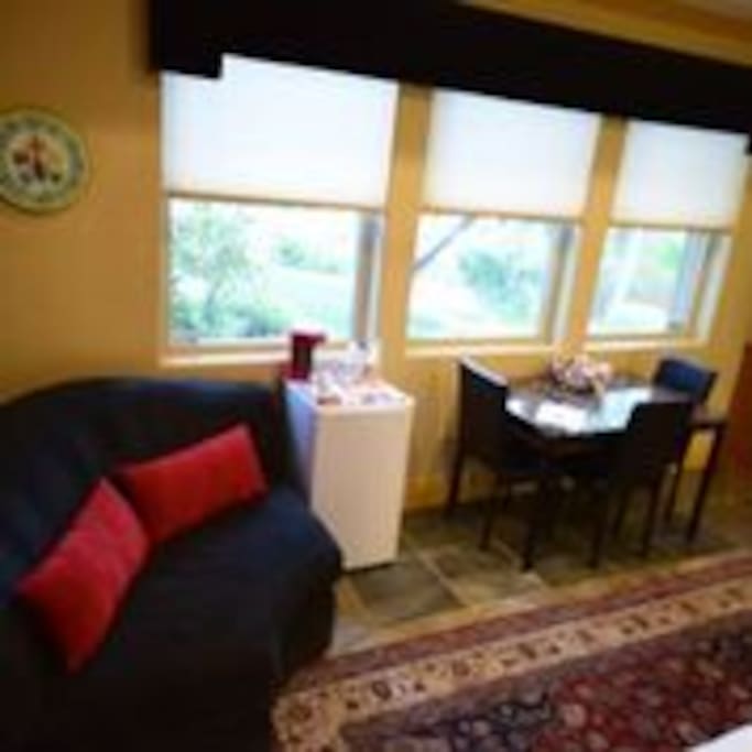 Private sitting area to view TV, stocked refrigerator and table and chairs for eating or work.