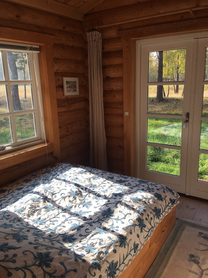 cama matrimonial con vista al bosque y al árbol