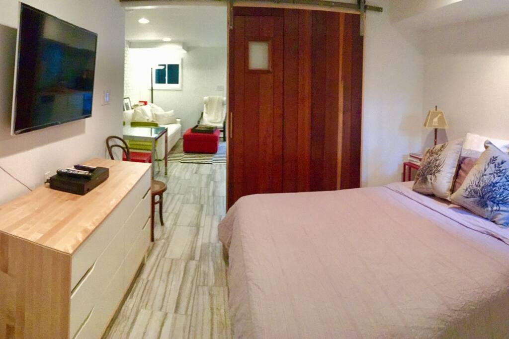 View from bedroom into living room with custom made cedar barn door. Our door within a door. If you pass through it you are changed for life for the better :)