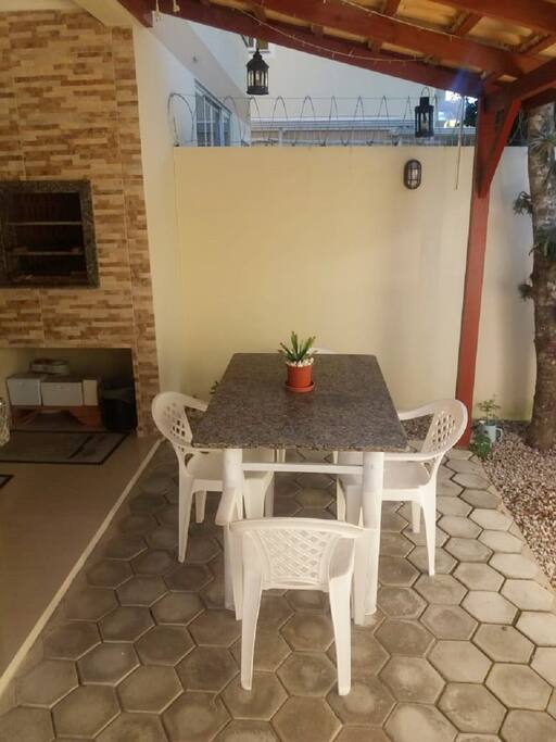 ÁREA EXTERNA COM JARDIM, MESA, PIA E CHURRASQUEIRA TODA PRIVADA PARA OS HOSPEDES RELAXAREM E PREPARAREM UM BOM CHURRASCO!