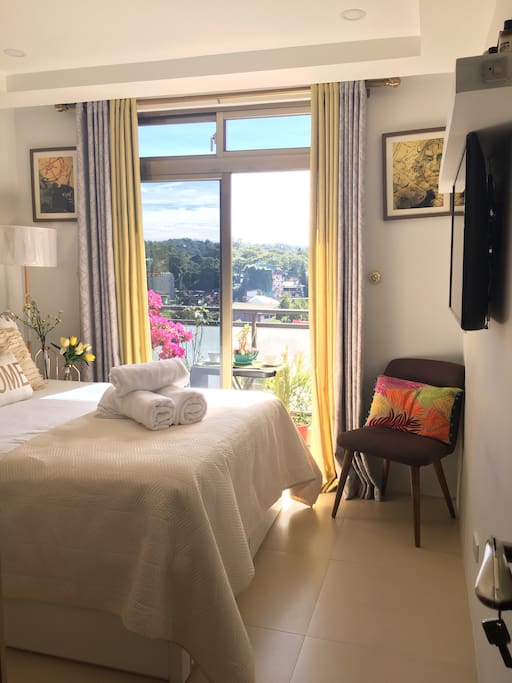 This is the master’s bedroom equipped with an en-suite toilet and shower, freshly laundered linens and towels , 4K LG flat screen TV with Netflix and YouTube unlimited streaming. It has a balcony with table and chairs for you to enjoy a nice afternoon tea with a lovely and relaxing view.