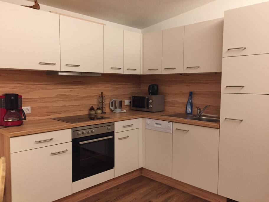 Küche mit Kochfeld, Backrohr, Kühlschrank und Gefrierfach, Geschirrspüler