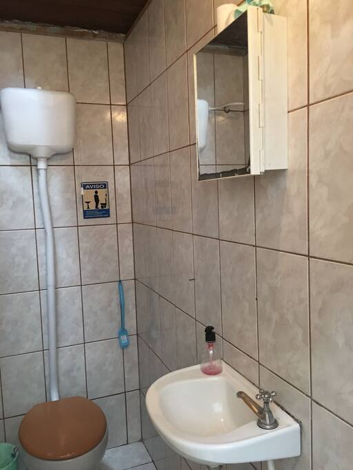 Banheiro simples, sem chuveiro, ao lado do mesmo o com chuveiro está.