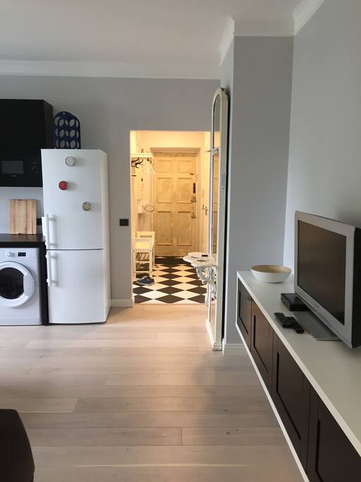 The interior follows a black&white mood with natural hardwood floors