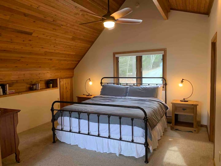 Dormitorio principal del piso superior con vista al mar: cama tamaño king