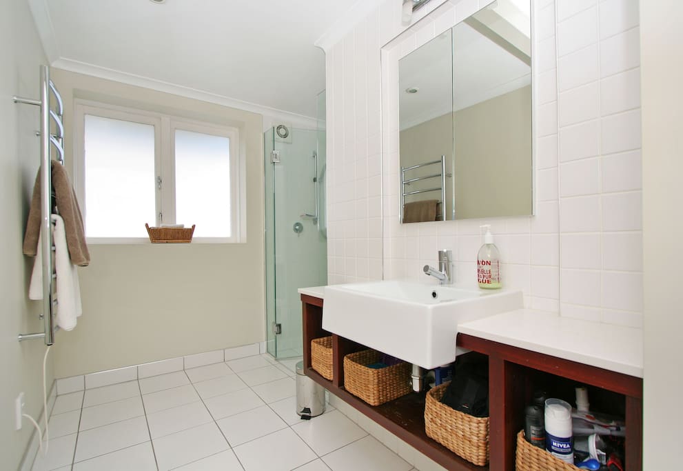 Bright, large tiled shower and bathroom with heated towel rail and complimentary soap, shampoo and conditioner.