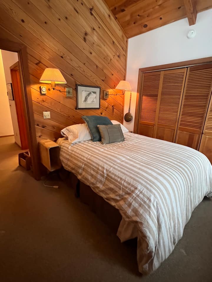 Cama tamaño queen con techo abovedado y loft con vistas a la montaña
