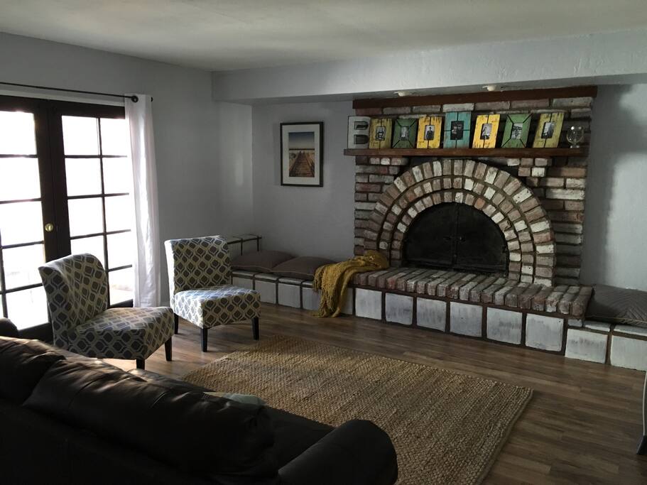 Living Room features a cozy fireplace and wood flooring. Double doors open to front porch.