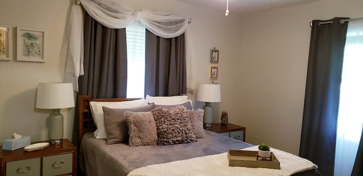 An ample bedroom with room darkening shades and curtains, a comfy queen bed, and a 3 speed ceiling fan make for a great night's sleep!