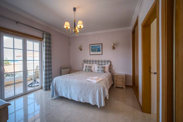 חדר שינה זוגי למעלה עם גישה למרפסת ונופי ים.