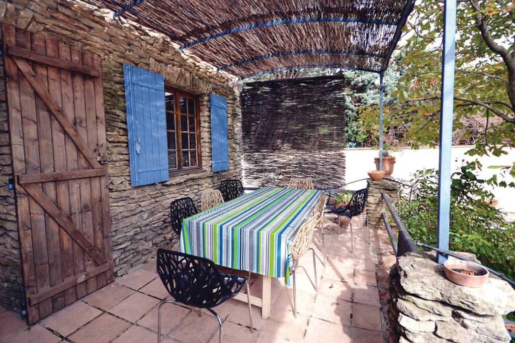 Aux heures les plus chaudes de la journée, vous préférerez prendre vos repas coté est, sur la terrasse à l'ombre des glycines.