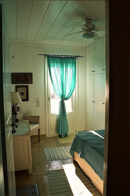 Bright with sunshine and door leading out onto balcony.