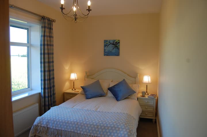 Otro de los dormitorios dobles.  Fabulosas vistas sobre los campos hacia la granja. Atractivos muebles de madera crema que incluyen un chiffarobe para desempacar la ropa.