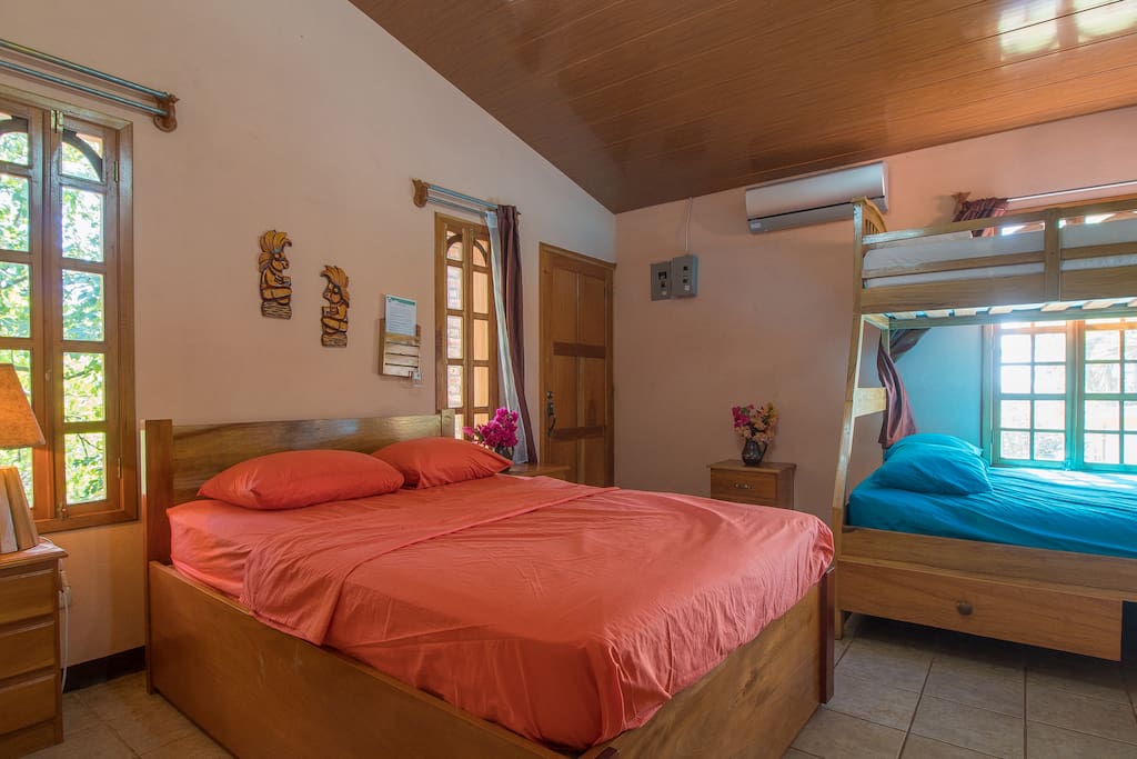 Una habitacion con dos camas matrimoniales, una cama unipersonal y un baño privado. Duermen 5 personas.