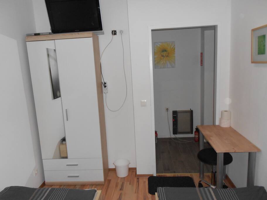 TV, Kasten, Tisch u. Sessel im Zimmer