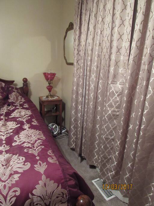 Bedroom 1, room darkening panels, ceiling fan and light, and floor fan for white noise