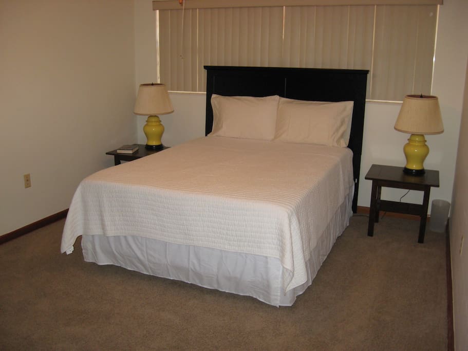Bedroom with queen bed, two bedside tables and lamps. Bed is high quality with firm support.
