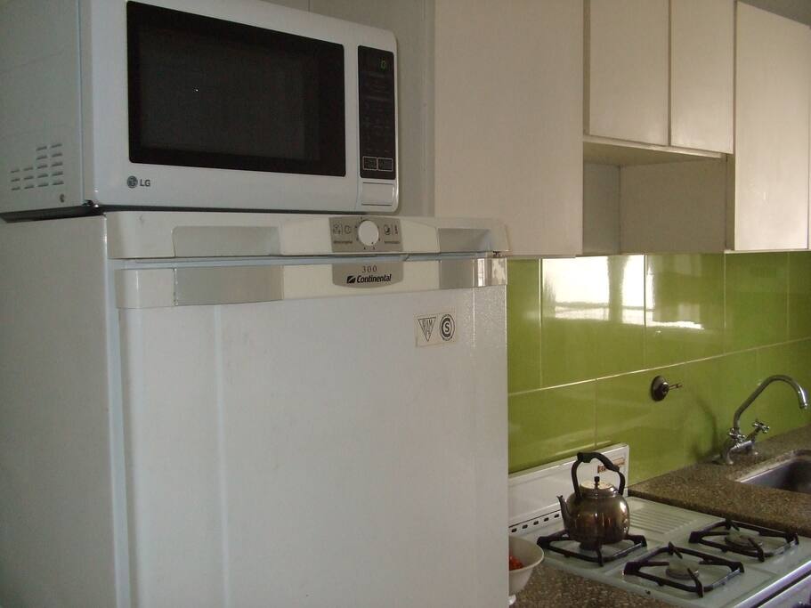 Cocina con nevera y microondas.