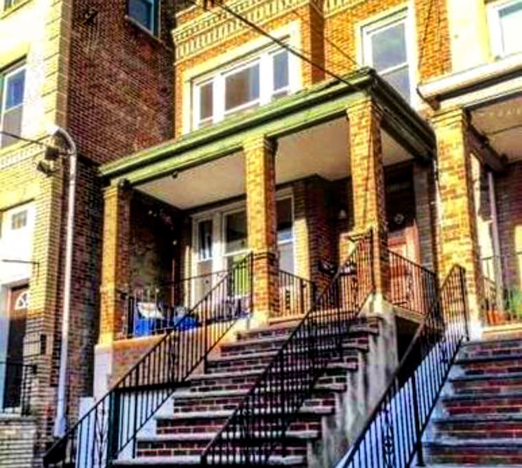enjoy the dramatic view of the New York City skyline from the front porch of this historic brick brownstone.